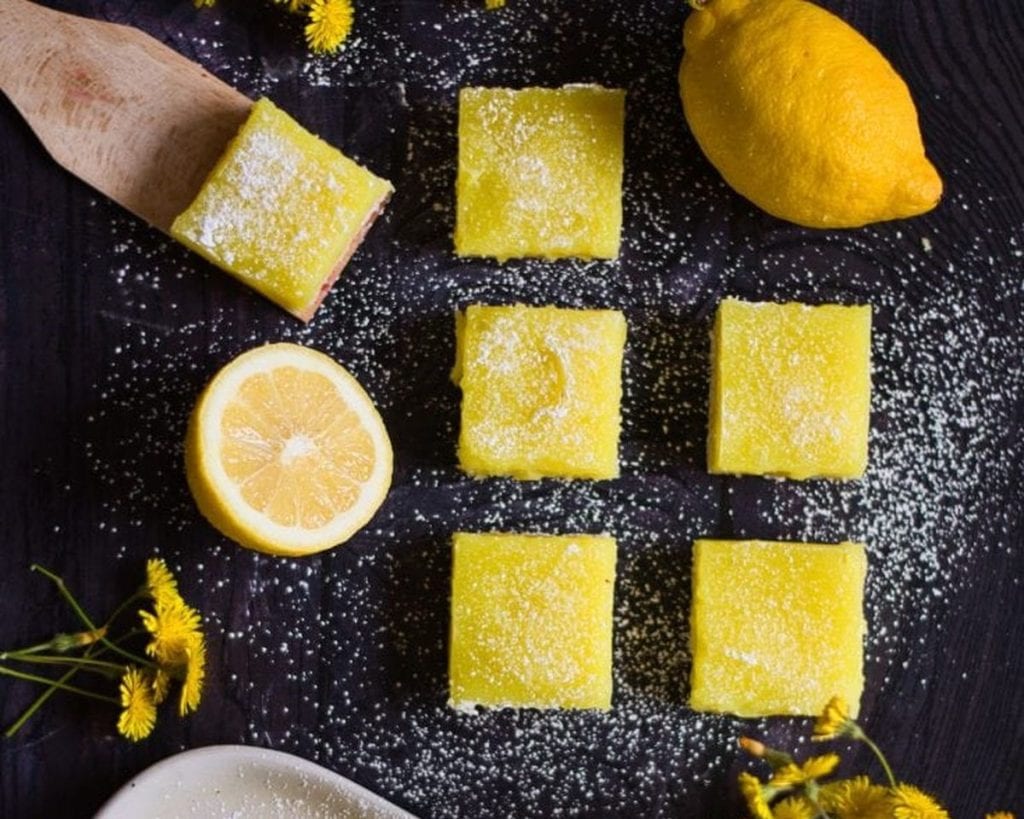 Lemon bars with powdered sugar and flowers.
